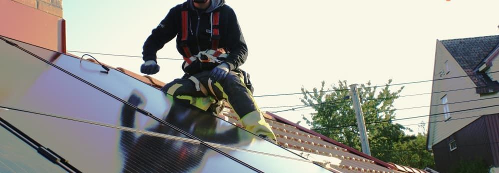 Person auf Dach installiert Solarmodule